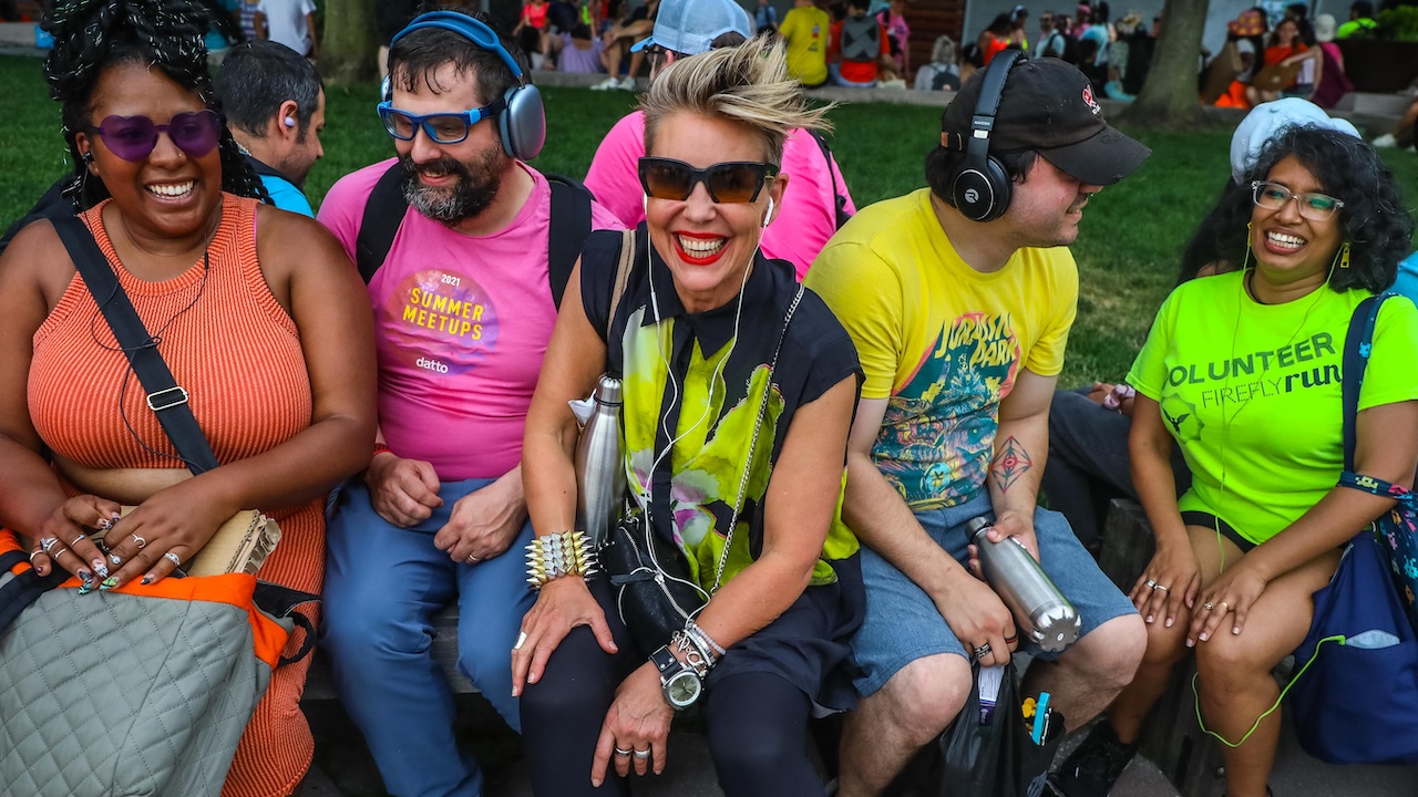People sitting on a bench wearing headphones for the Mp3 Experiment 19